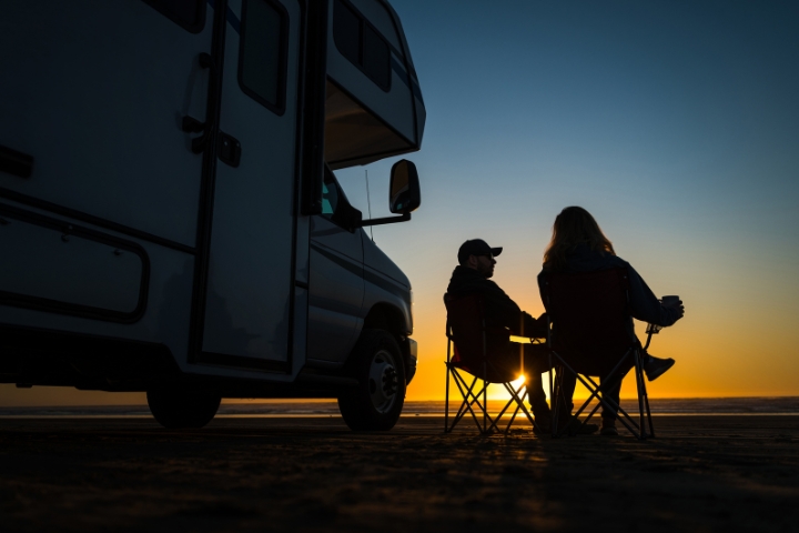 couple sitting on a chair outside their rv