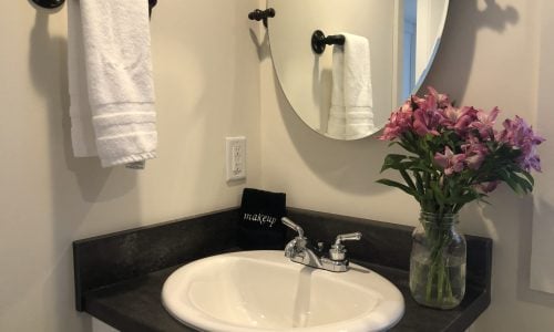 Tiny Home Stays 187 bathroom sink with towel and flower vase